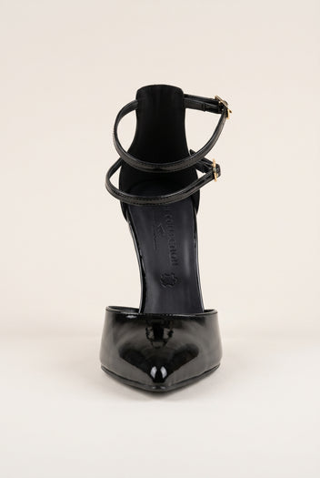 Front view of black patent pump showing the pointed toe box and crossed ankle straps with buckle