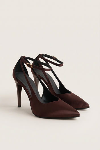 Pair of brown satin ankle-strap pumps seen at an angle with pointed toes and a slim stiletto heel