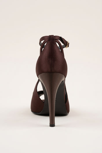 Back view of a brown satin ankle-strap pump with crossed straps at the heel and a tall stiletto heel
