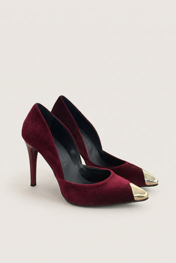 Pair of bordeaux velvet pumps seen at an angle showing gold metal toe caps and cut-away sides