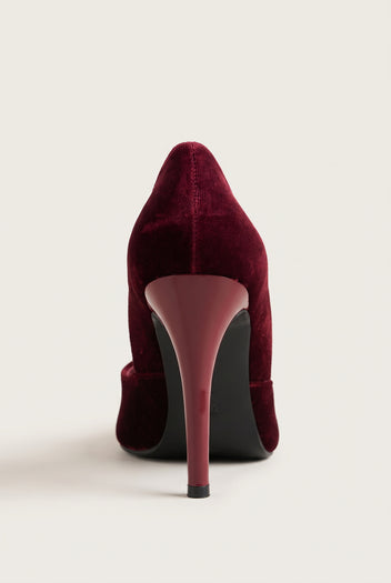 Back view of a bordeaux velvet pump with a tall slim heel in a matching bordeaux tone