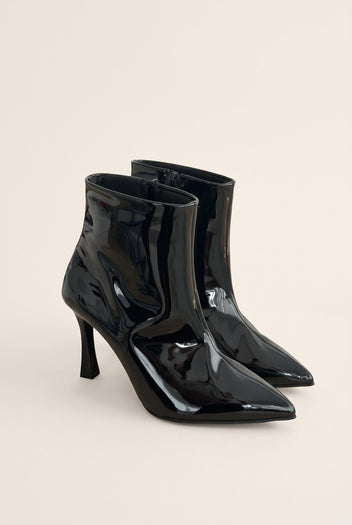 Pair of black patent pointed toe ankle boots with slim stiletto heels in angled front view