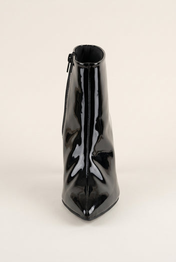 Front view of black patent ankle boot with pointed toe facing forward and a narrow zip at the top edge