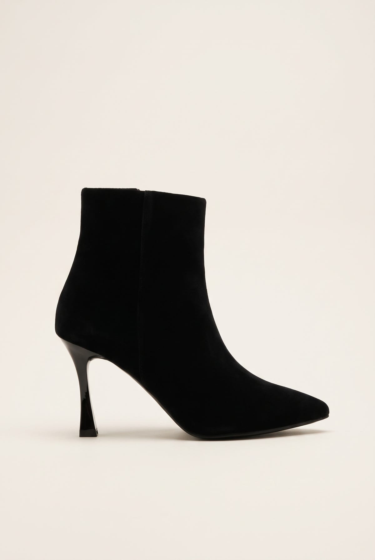 Black velvet pointed toe ankle boot with slim stiletto heel and side zip in side view on a light surface