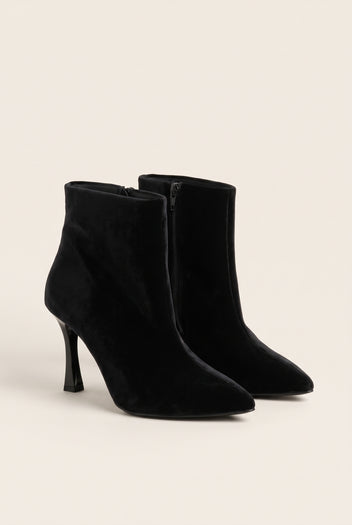 Pair of black velvet pointed toe ankle boots with stiletto heels in angled front view