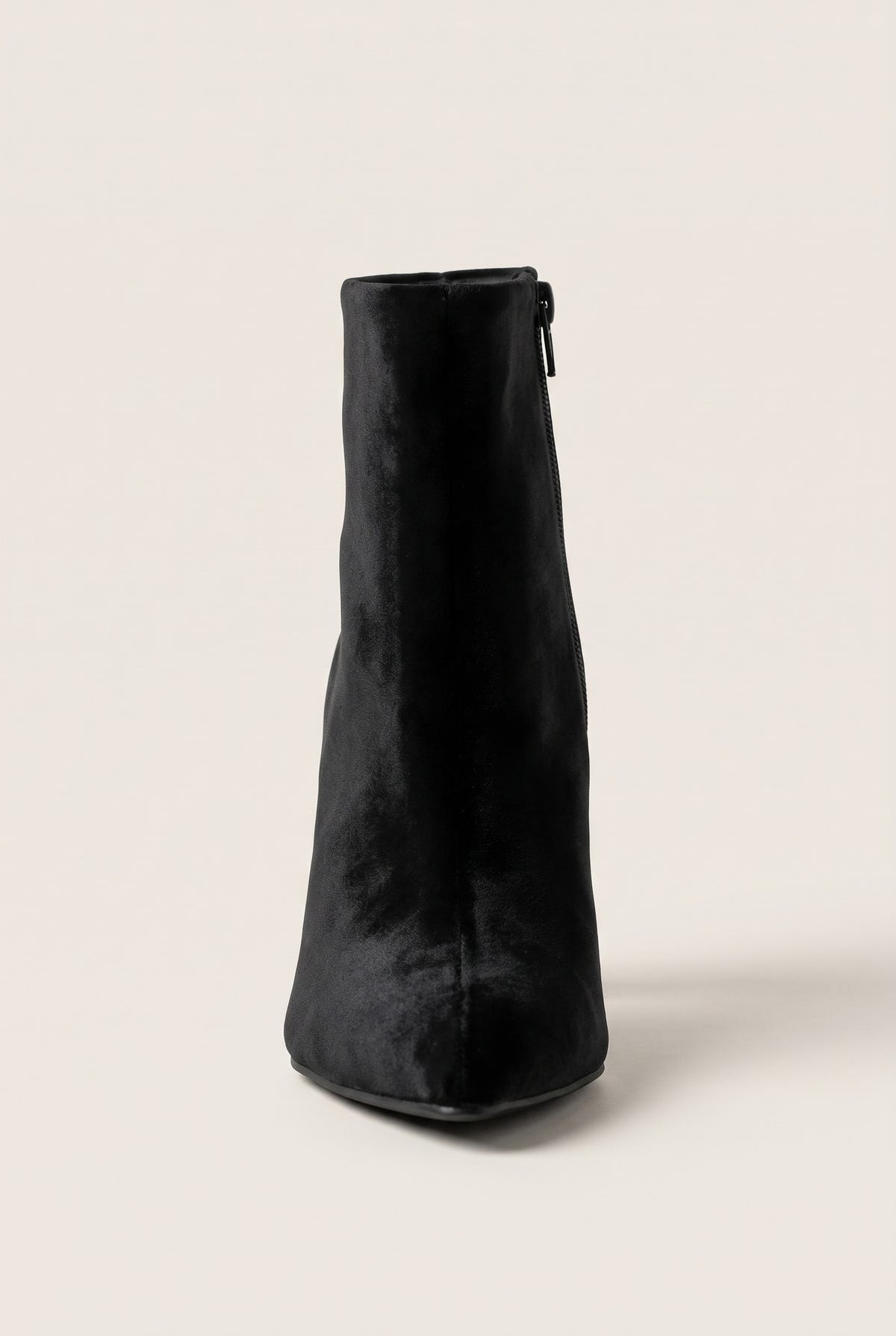 Front view of black velvet ankle boot with narrow pointed toe and slim zip detail at the top of the shaft