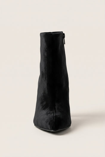 Front view of black velvet ankle boot with narrow pointed toe and slim zip detail at the top of the shaft