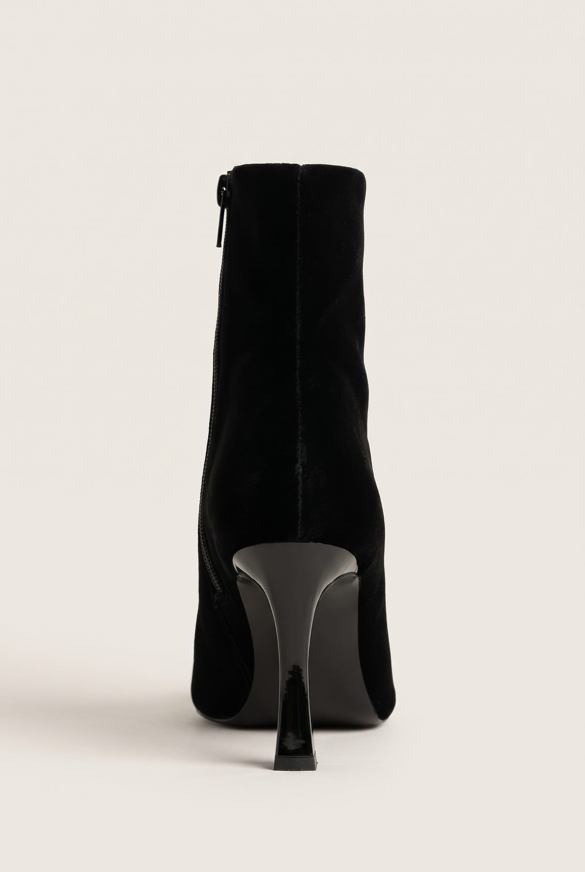 Back view of black velvet ankle boot showing the vertical rear zip and sculpted stiletto heel