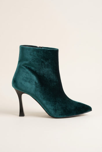 Dark green velvet pointed toe ankle boot with slim stiletto heel in side view on a light surface