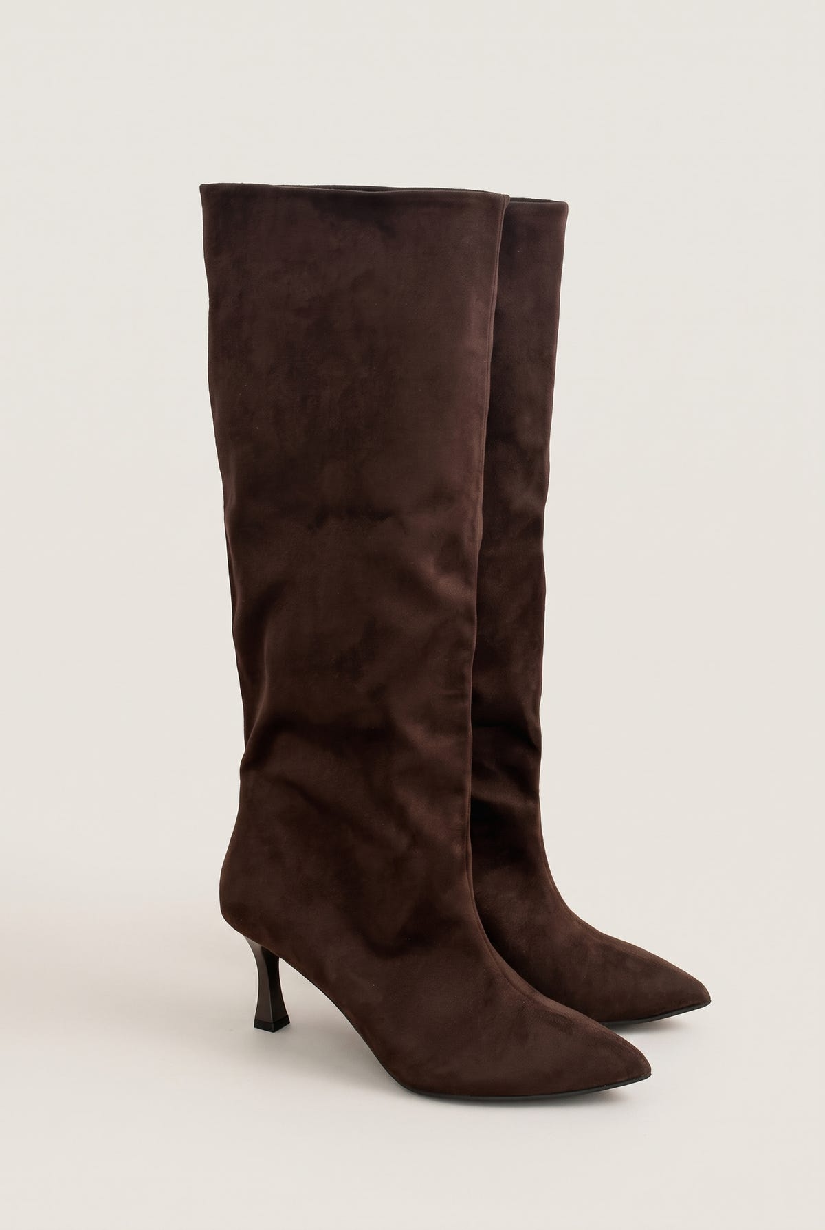 Pair of brown suede knee-high stiletto boots with pointed toes and a slouchy shaft, front three-quarter view