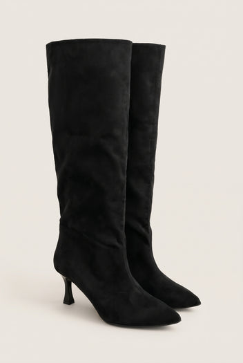 Pair of black suede knee high stiletto boots with pointed toes in angled front view