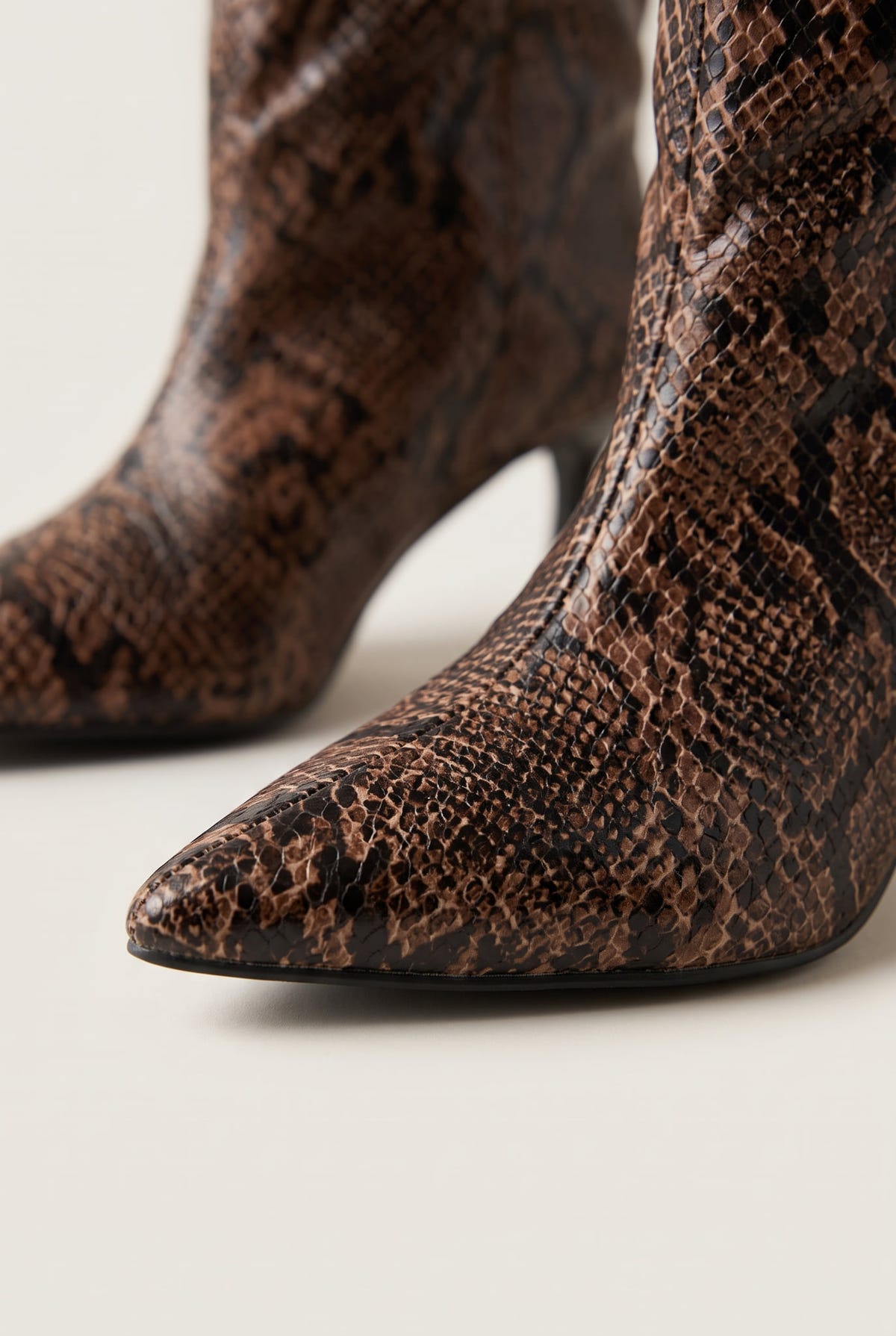 Close-up of brown snake print boot with pointed toe and slim heel showing the textured scale pattern