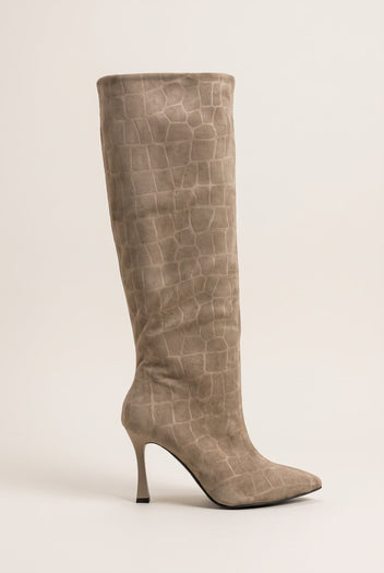 Full view of a knee-high beige croc-embossed suede boot with a pointed toe and a slim stiletto heel