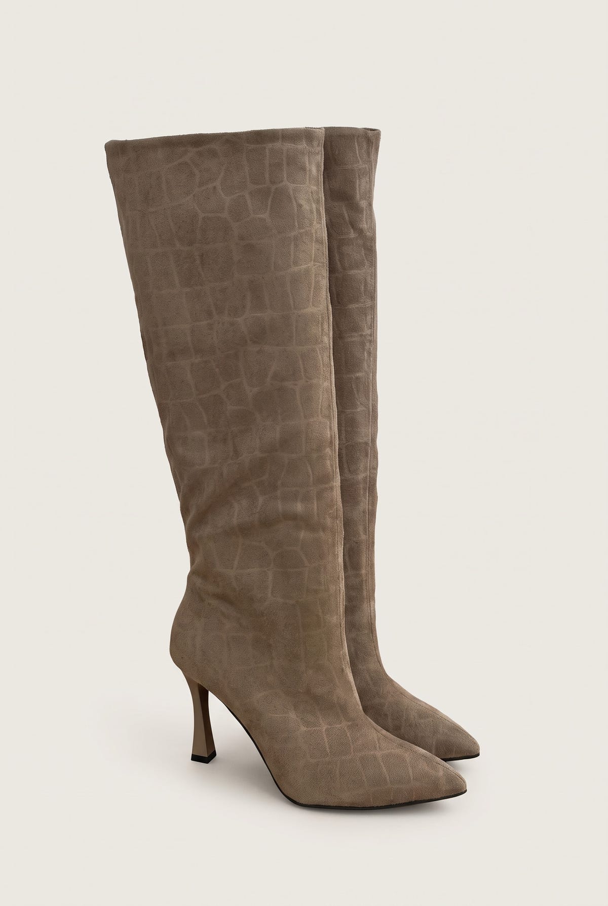 Pair of knee-high beige croc-embossed suede boots standing side by side with pointed toes