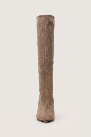 Front view of a tall beige croc-embossed suede boot with a narrow shaft and a pointed toe