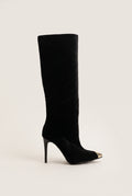 Black velvet knee high pointed toe boot with gold tone metal toe cap and stiletto heel in side view