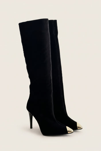 Pair of black velvet knee high boots with gold tone metal toe caps in angled front view