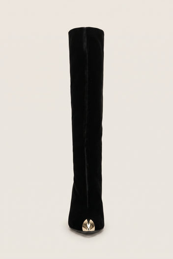 Front view of black velvet knee high boot with a pointed toe and gold tone metal cap at the tip