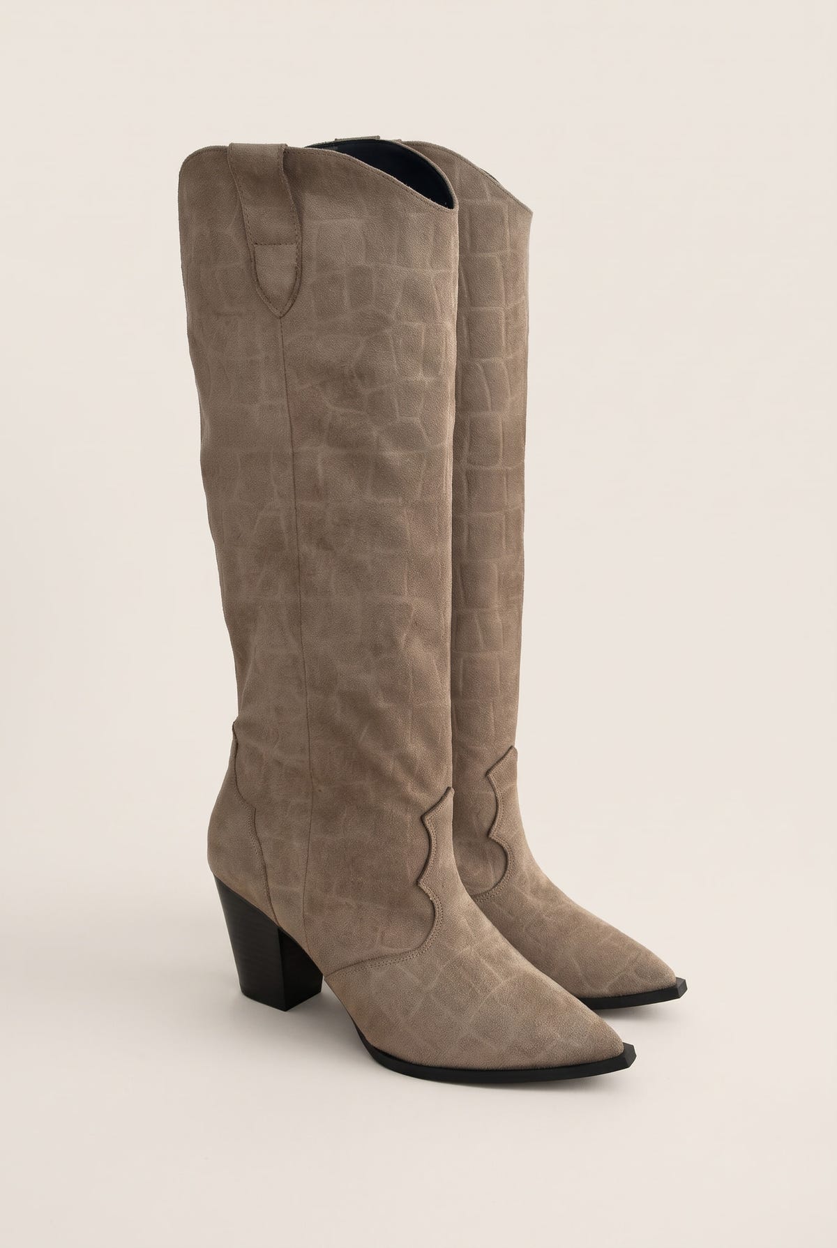 Pair of beige croc embossed suede cowboy boots with stacked heels in angled front view