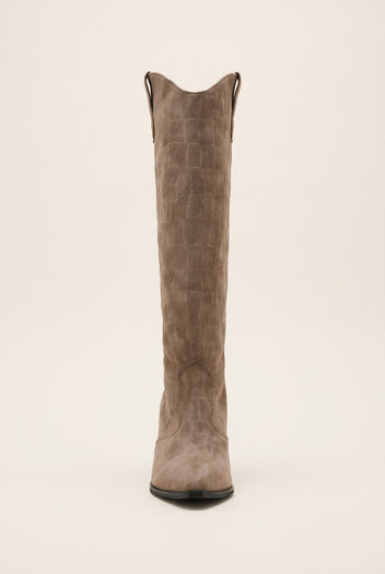 Front view of beige croc suede cowboy boot showing the notched V top edge and pointed toe