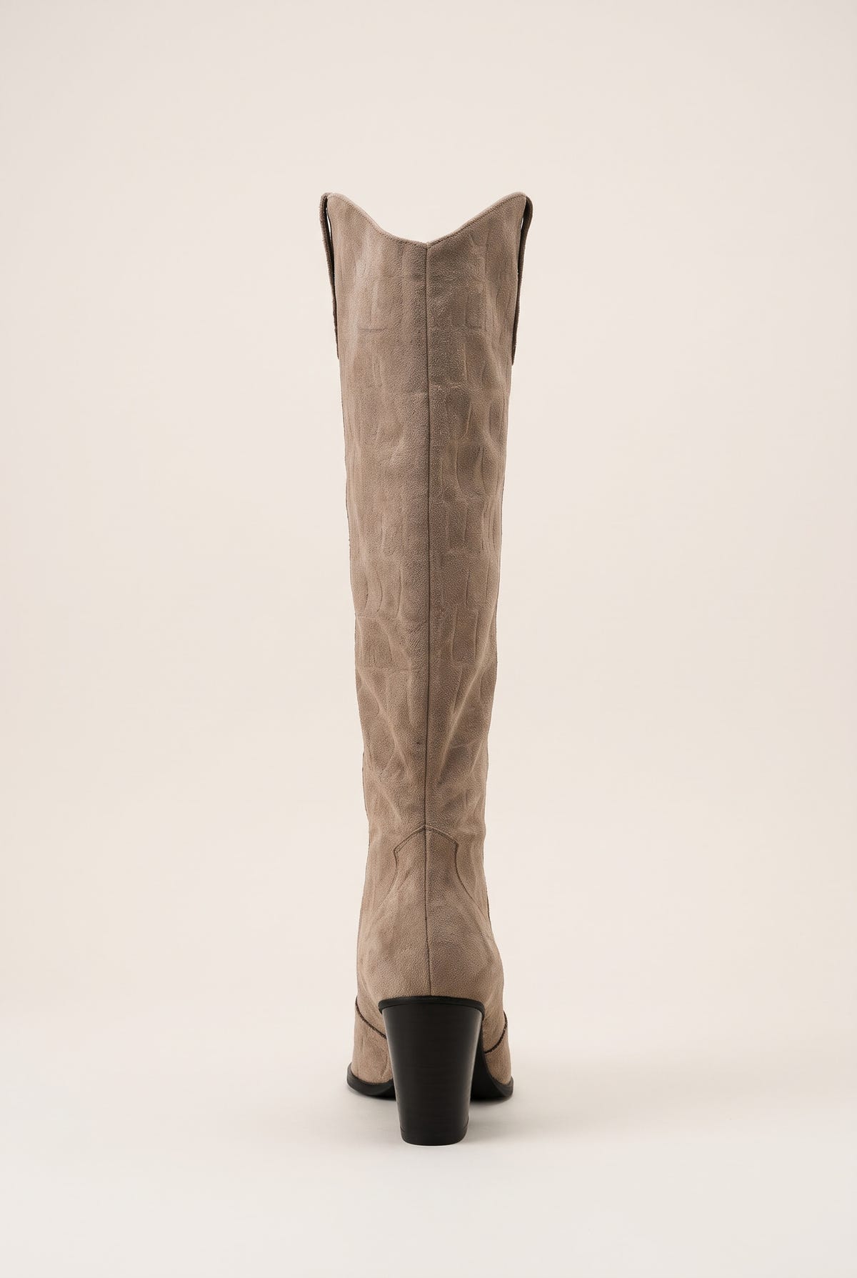 Back view of beige suede cowboy boot showing the notched V top edge and stacked heel