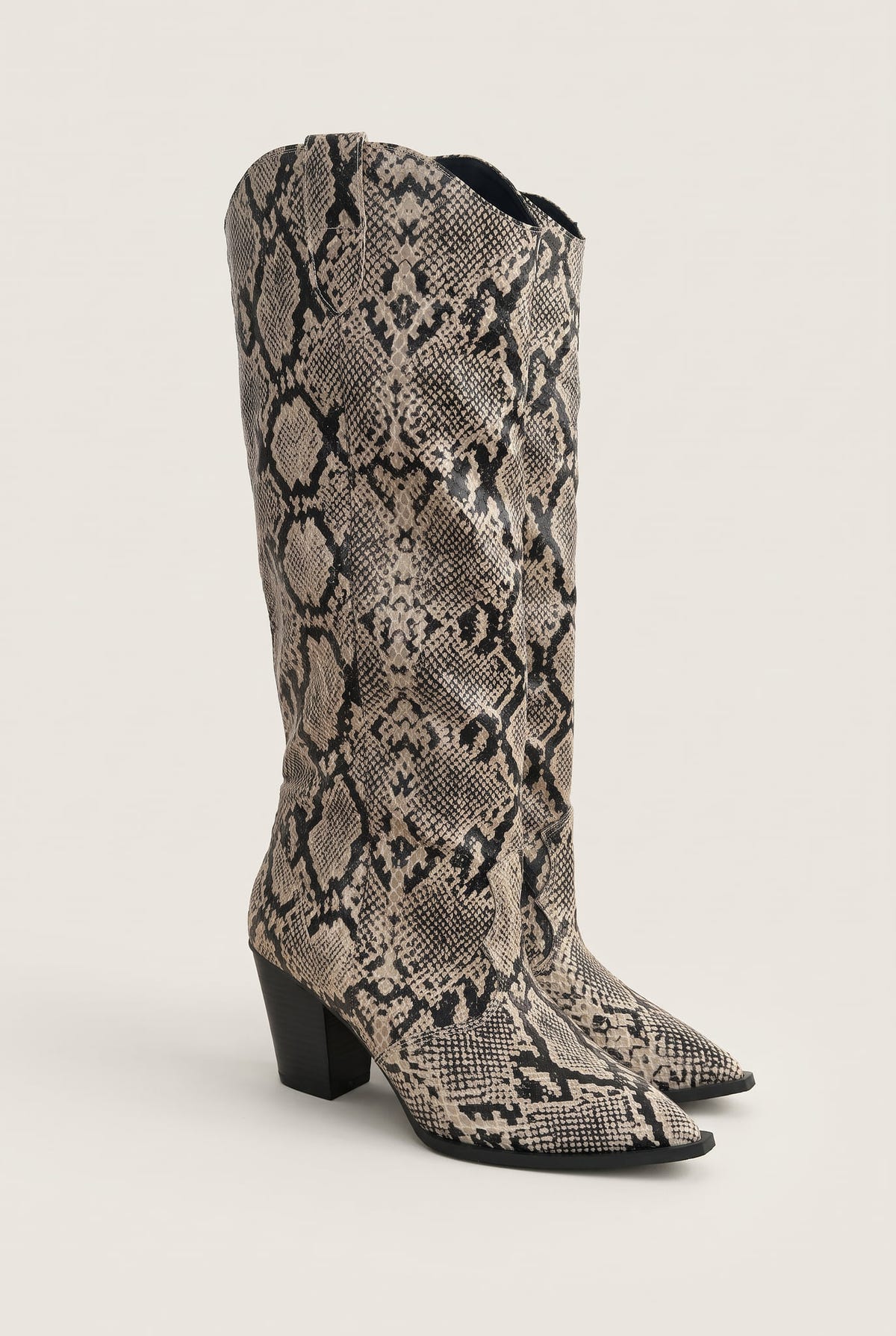 Pair of ivory and black snake print cowboy boots with stacked heels in angled front view