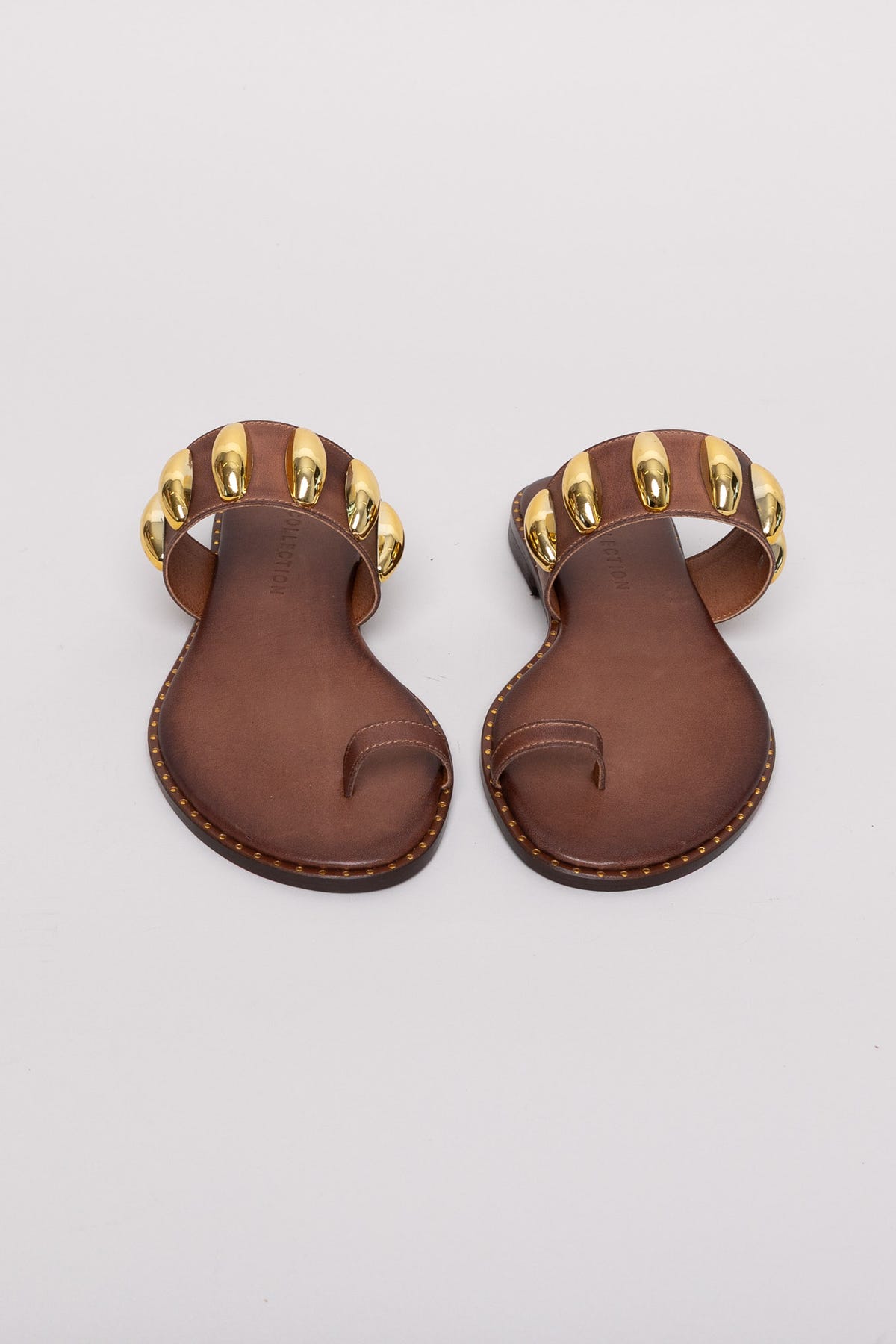 Brown leather toe-ring sandals with gold studs, pair view on grey background in studio light