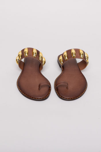 Brown leather toe-ring sandals with gold studs, pair view on grey background in studio light