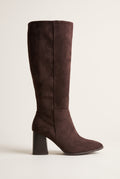 Single dark brown suede knee-high boot with a pointed toe and chunky block heel, side view on a light surface