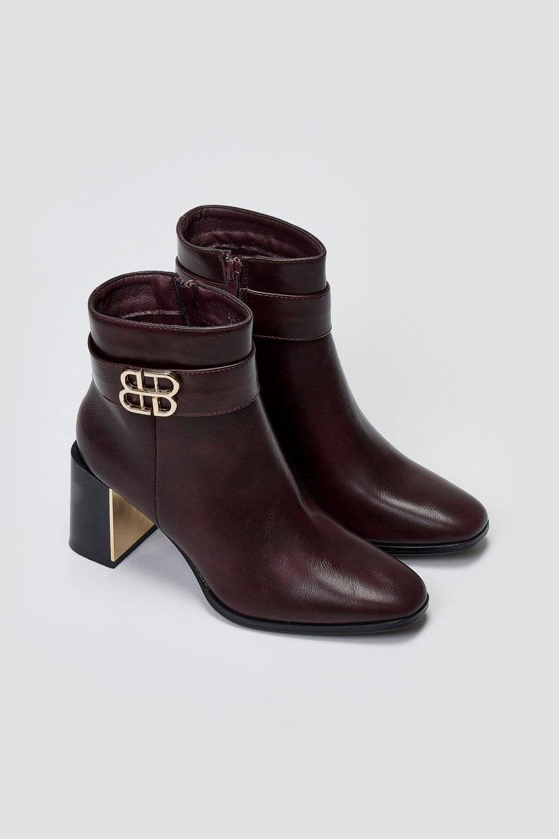 Burgundy leather ankle boots with block heel and gold-tone logo buckle, pair in angled view on a light grey background
