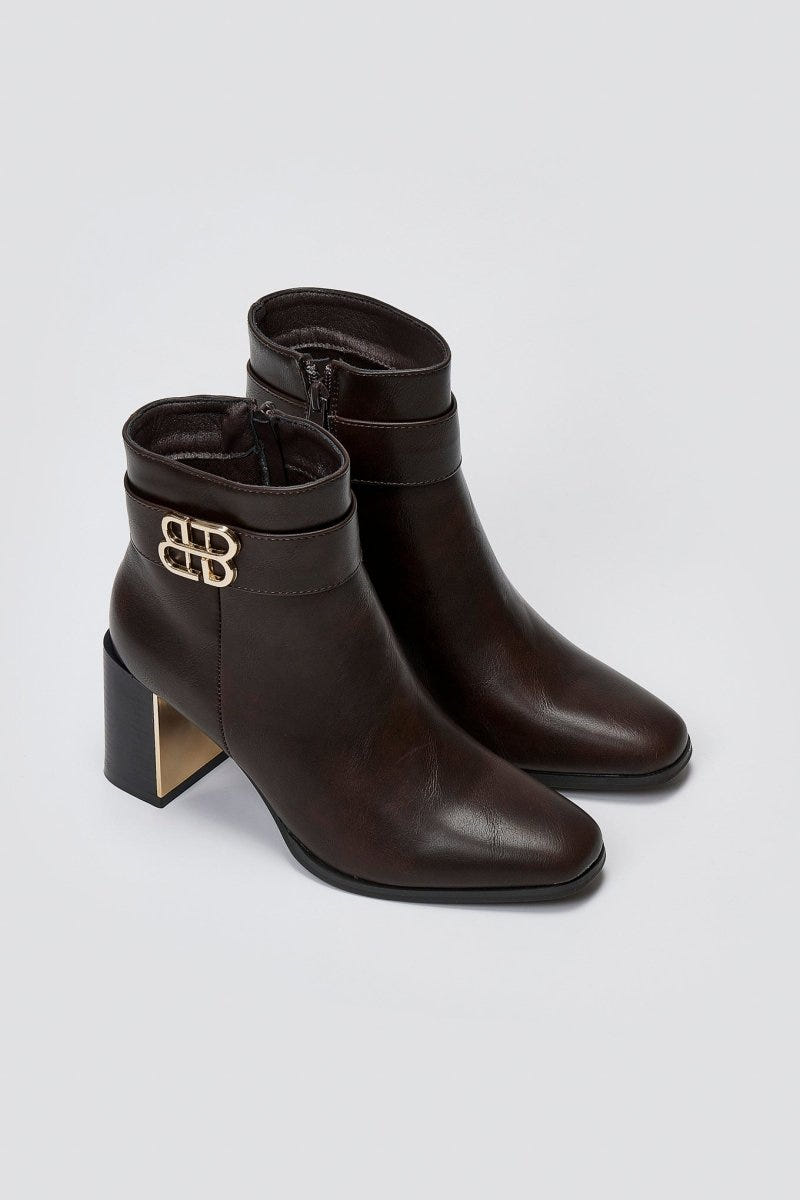 Dark brown leather ankle boots with block heel and gold-tone logo buckle, pair in angled view on a light grey background