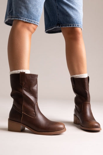 Dark brown leather mid-calf boots with block heel and side panel, pair in angled view on a model's legs in studio light