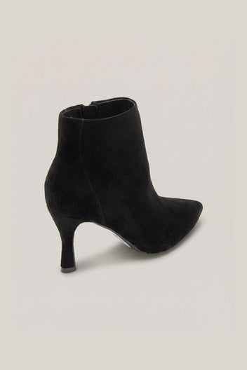 Black suede pointed-toe ankle boot with stiletto heel and side zip, angled view on a light grey background