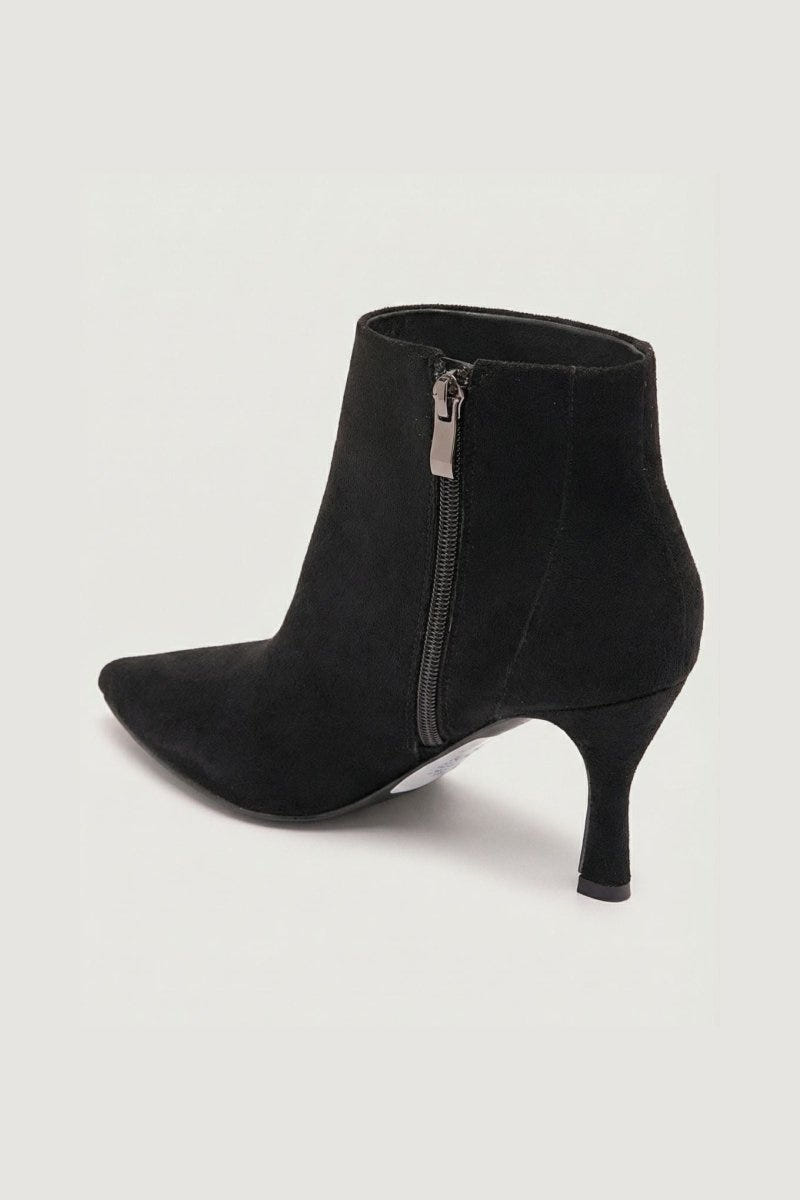 Black suede pointed-toe ankle boot with stiletto heel and side zip, angled side view on a light grey background
