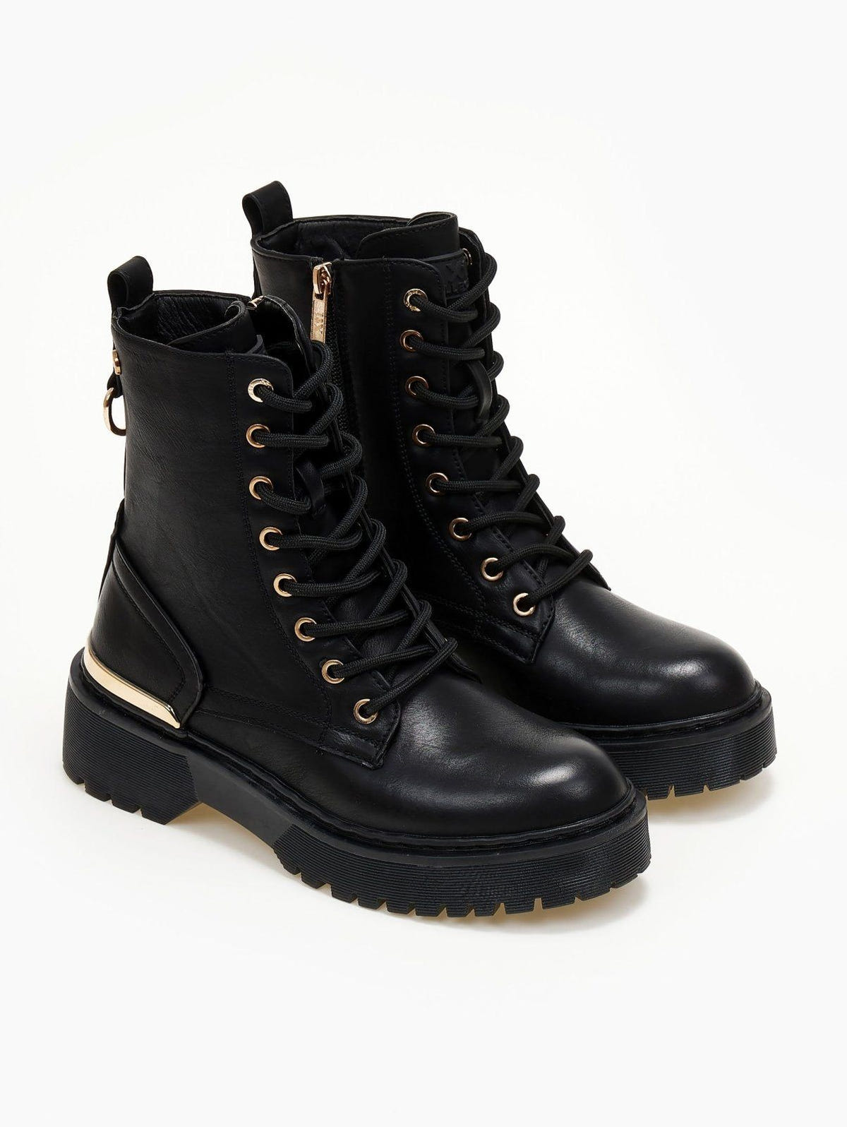 Pair of black lace-up leather boots with gold eyelets, gold trim and chunky sole on a white background