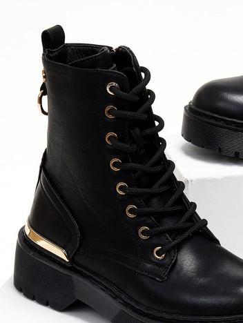 Close-up side view of black lace-up boot with gold eyelets, gold trim and chunky sole