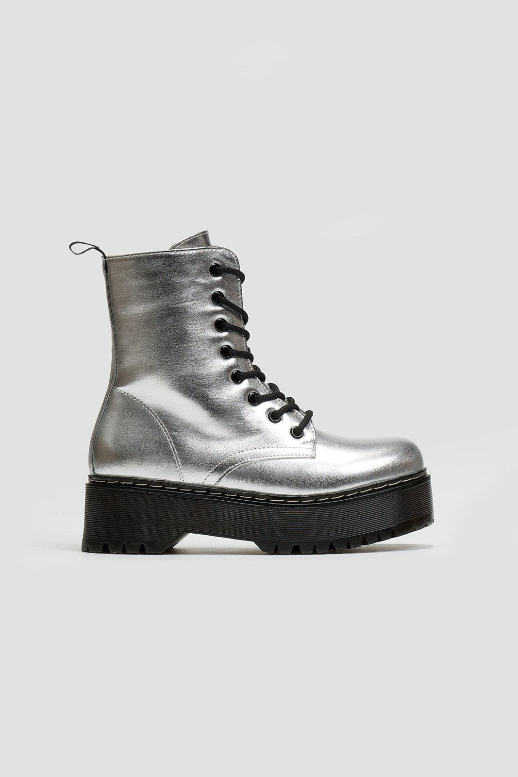 Silver metallic lace-up boot with black chunky sole, side view on light grey background
