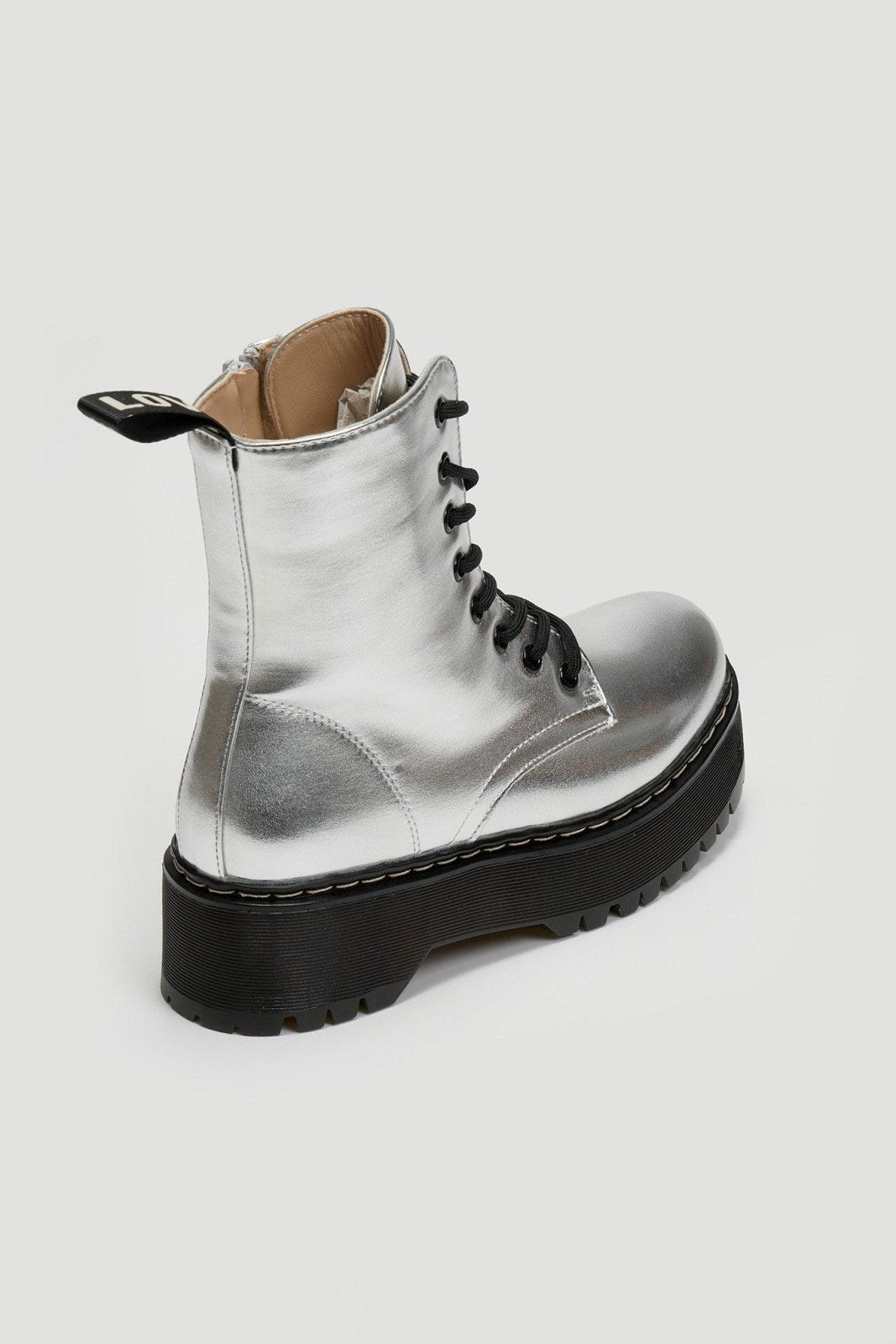 Silver metallic lace-up boot with black chunky sole and beige interior, angled view on grey background