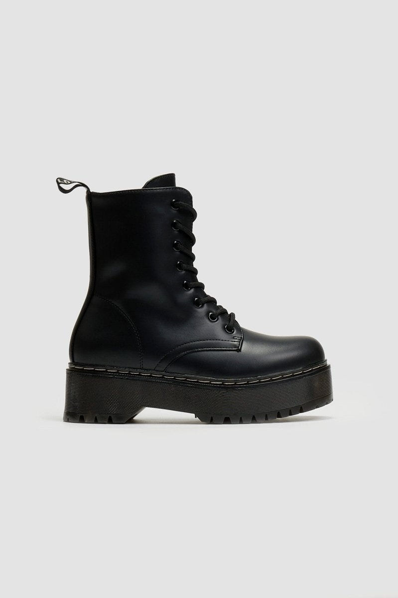 Black leather lace-up boot with chunky black platform sole, side view on light grey background