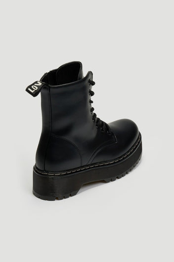 Black leather lace-up boot with pull tab and chunky black platform sole, side view on grey background