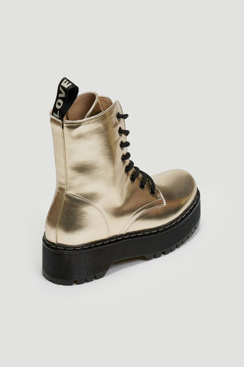 Gold metallic lace-up boot with black chunky sole and pull tab, angled view on light grey background