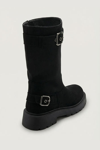 Black suede knee-high boot with buckle strap and chunky sole, side view on light grey background