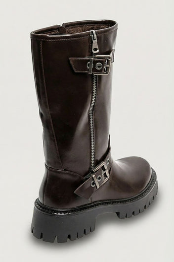 Brown glossy leather knee-high boot with buckle straps and lug sole, angled view on light grey background