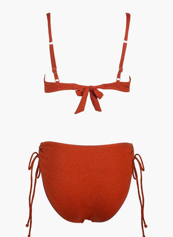 Rust orange underwire bikini top with tie front and rust orange bikini bottom with side ties, laid flat on white