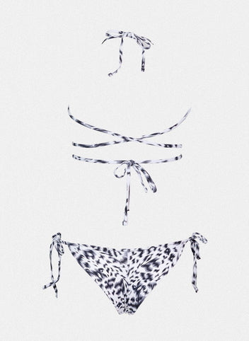 Navy and white leopard print string bikini top with wrap tie and matching side-tie bikini bottom, laid flat on white