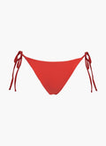 Red side-tie bikini bottom with thin tie straps and high-cut back, laid flat on white background