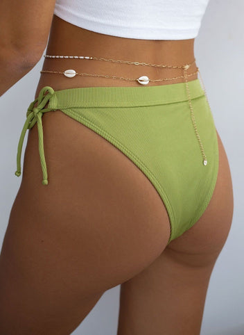 Model seen from behind wearing lime green ribbed bikini bottom with waist chains and tie side, close-up