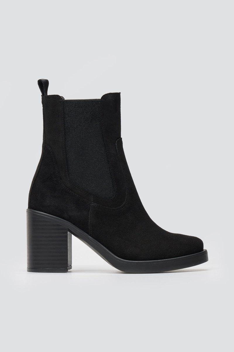 Black suede Chelsea ankle boots with block heel and elastic side panels, side view on light backdrop