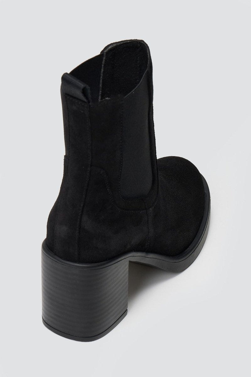 Black suede Chelsea ankle boot with block heel and elastic side panel, angled view on light backdrop