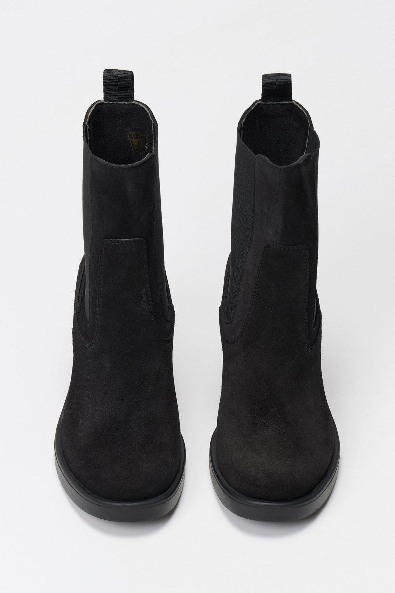 Black suede Chelsea ankle boots with block heel and elastic side panels, front view on light backdrop